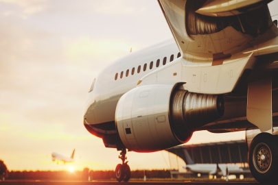 White commercial airplane standing on the airport runway at sunset. Passenger airplane taking off. Airplane concept 3D illustration.